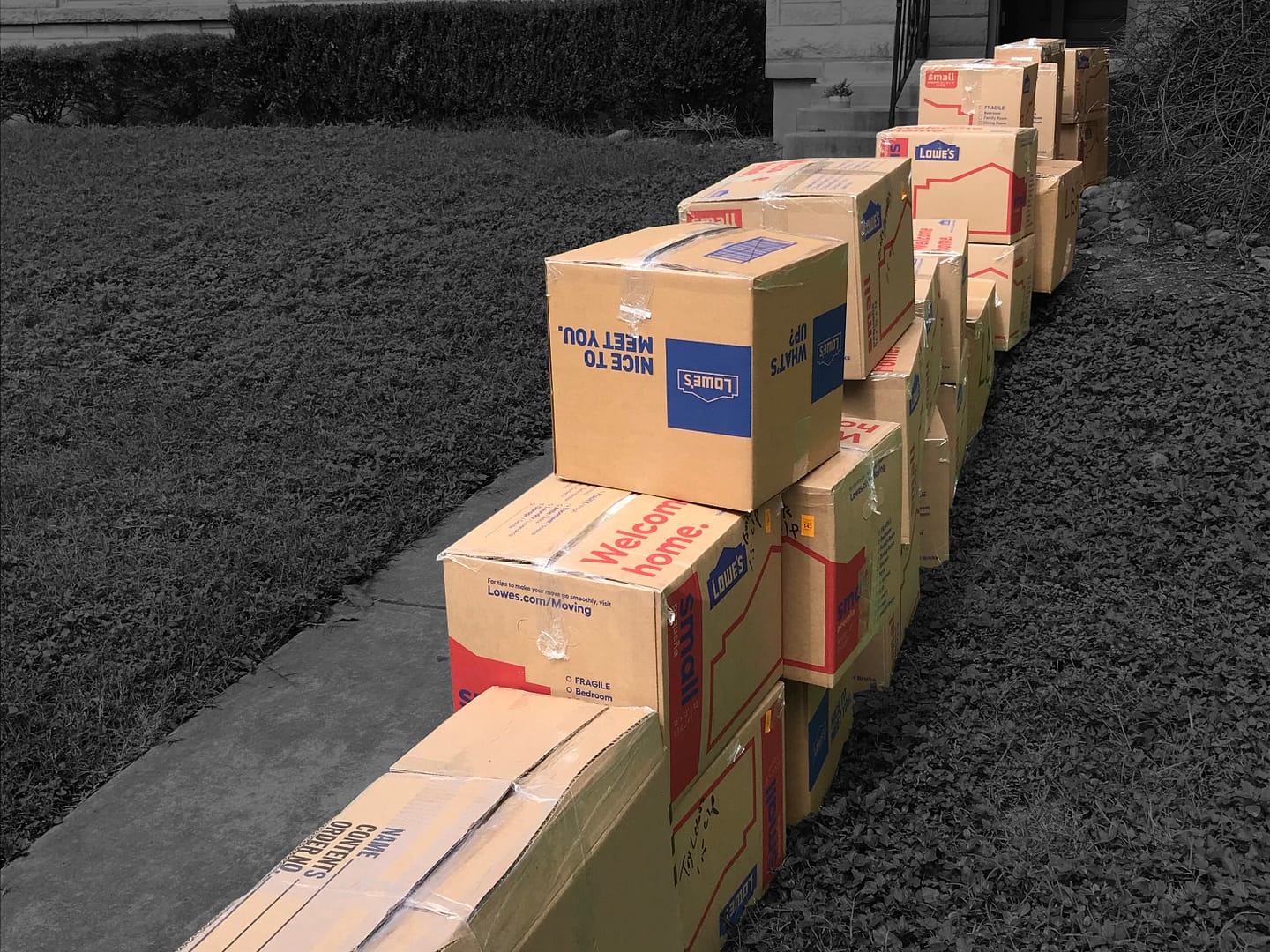 Cardboard moving boxes in a row over a black and white background.