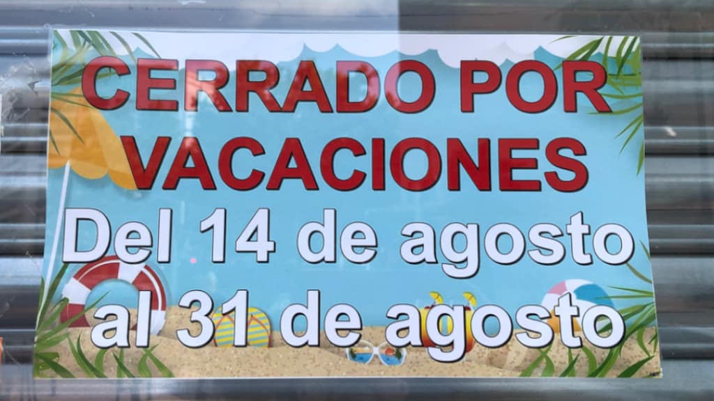 Sign in business window with the words "Cerrado por vacaciones" in Spanish - translated "Closed for vacation."