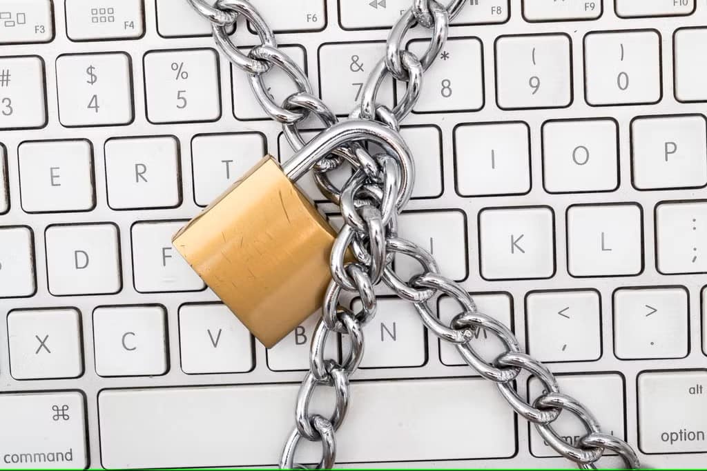 Computer keyboard shown with chains and lock across it.