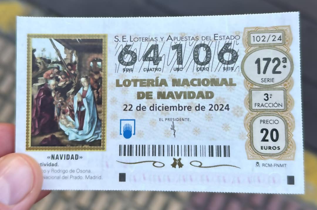Fingers holding Spain's Lotería de Navidad ticket.