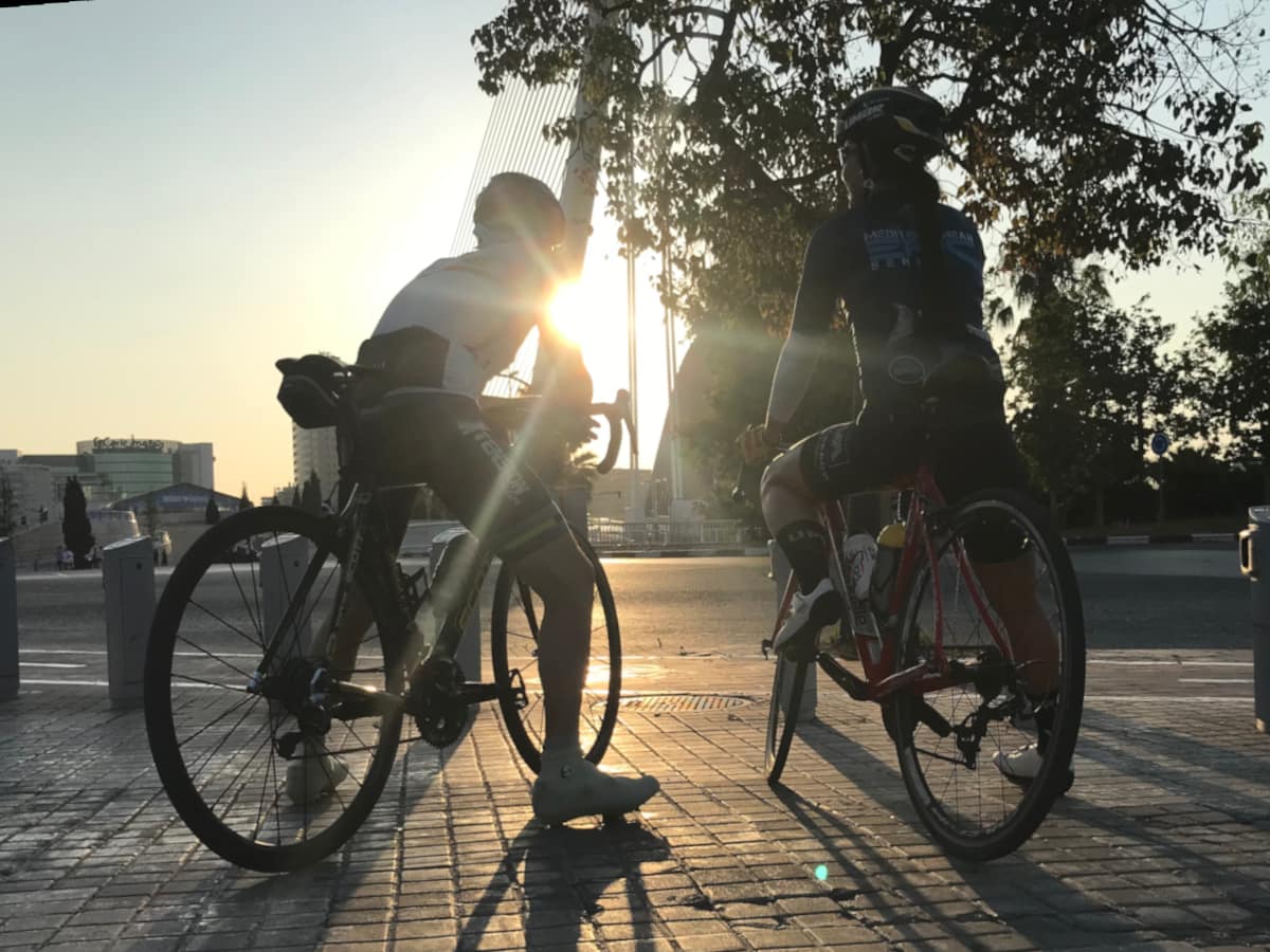 Two cyclists are silhouetted by the morning sun before a ride in Valencia, Spain.
