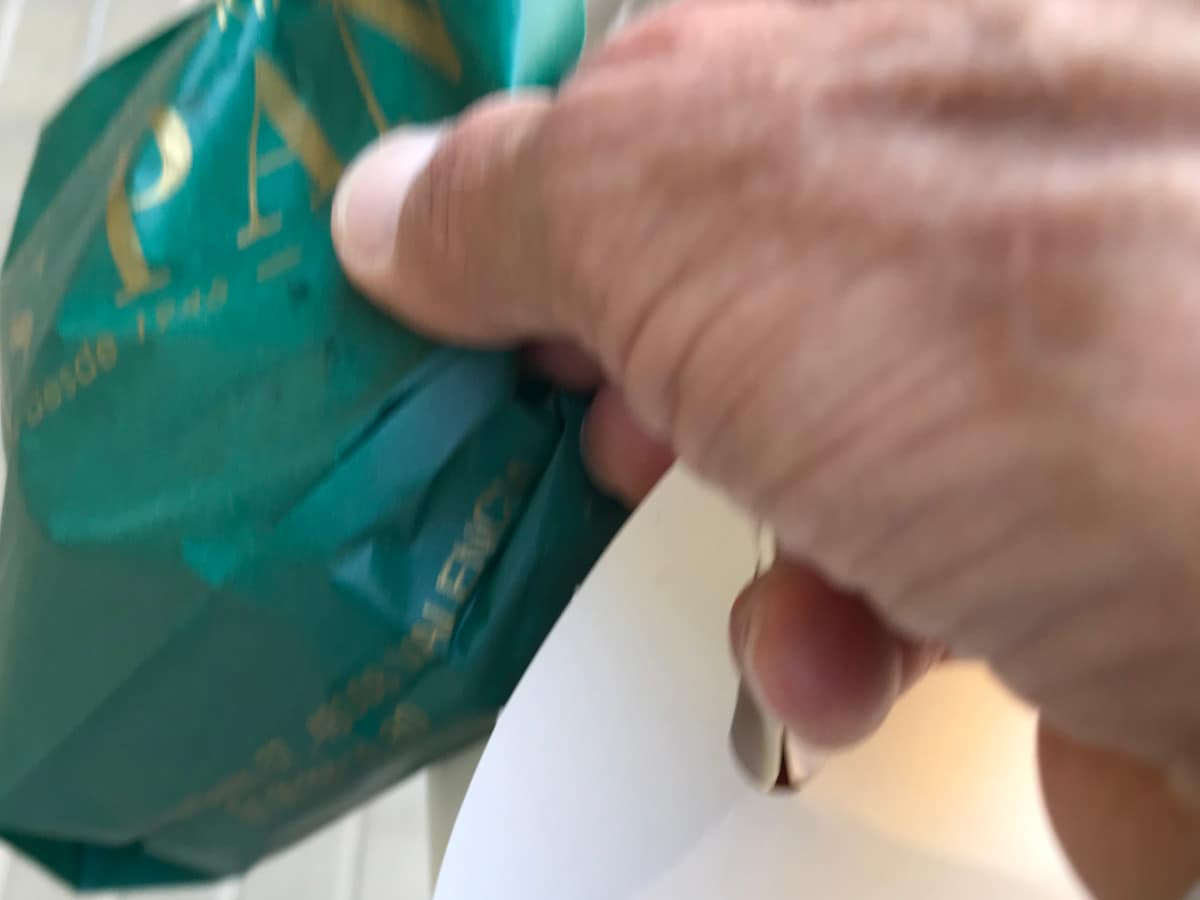 A hand holds two bags.