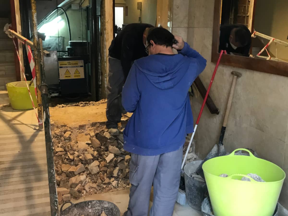 Workers standing among the rubble from redoing the elevator access.