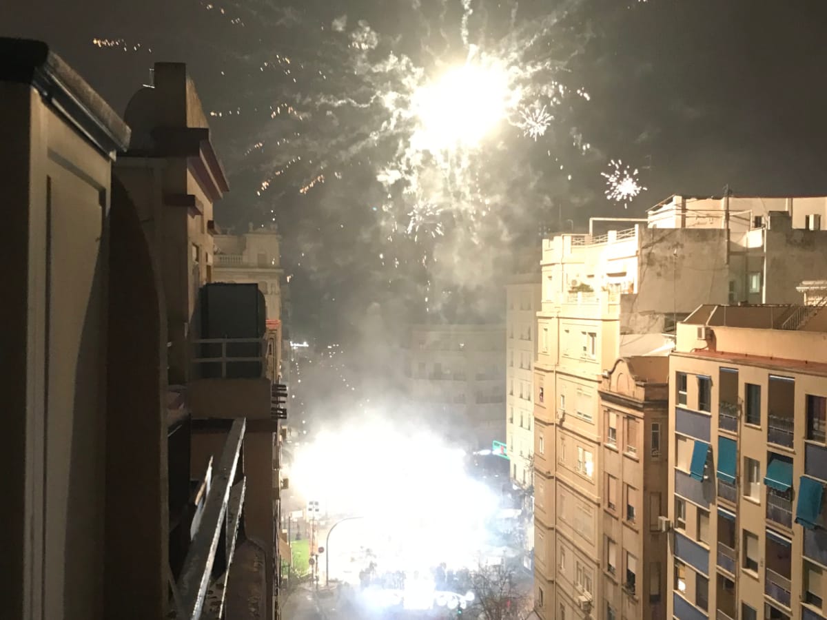Las Fallas fireworks exploding over a city street.