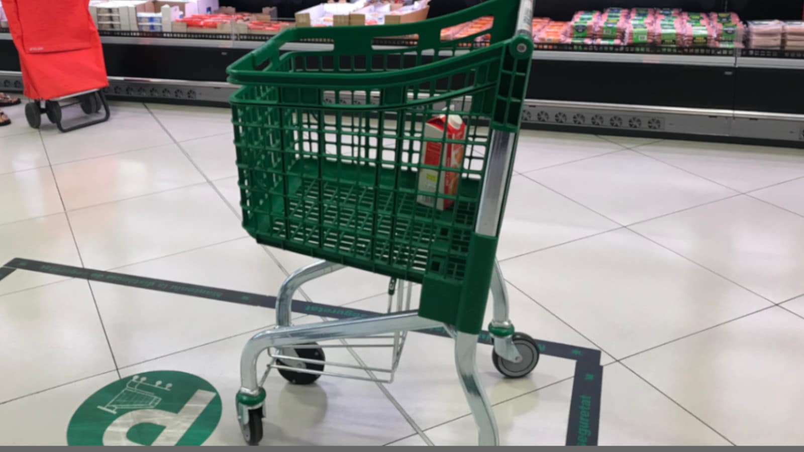 A shopping cart parked within the green lines.