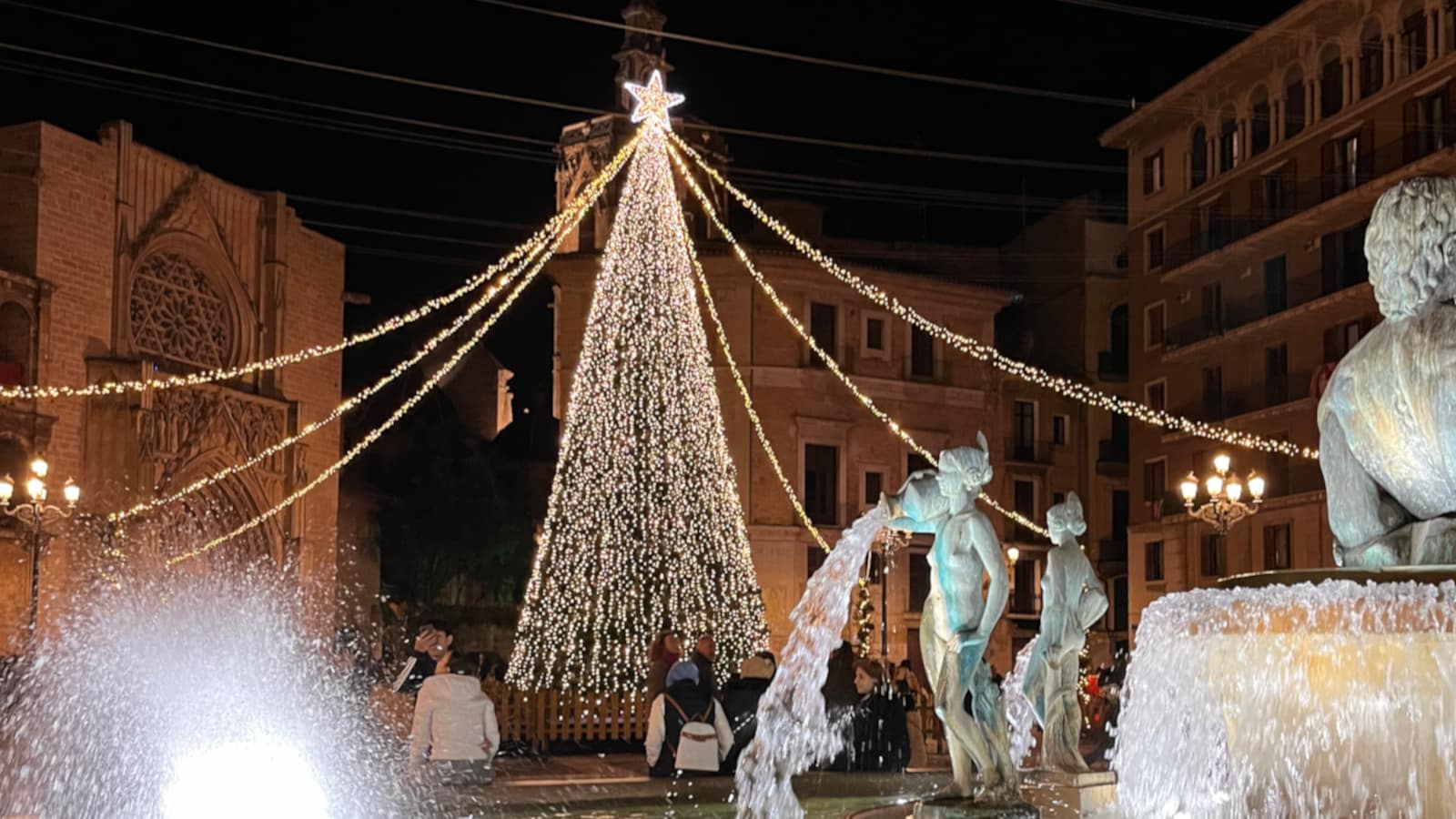 An illuminated Christmas tree near the "Fuente de las Acequias" in the "Plaza de la Virgen."