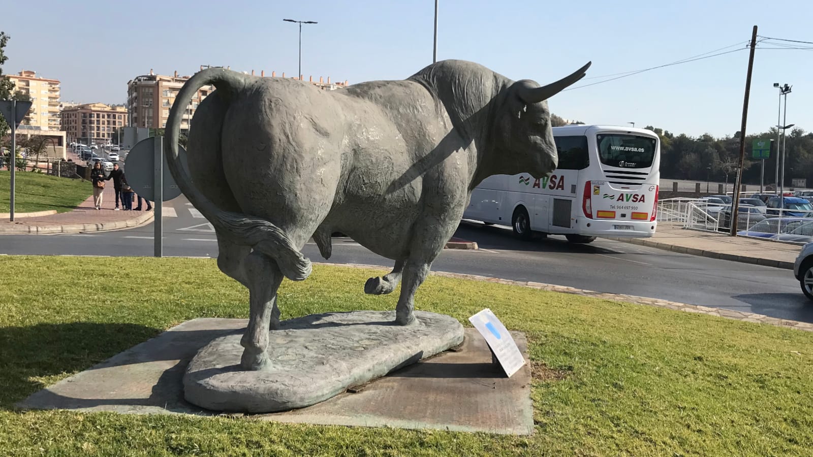 A large sculpture of a bull in a roundabout