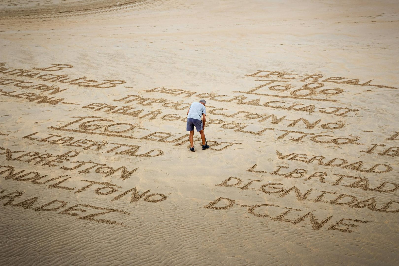 a person writing on the sand