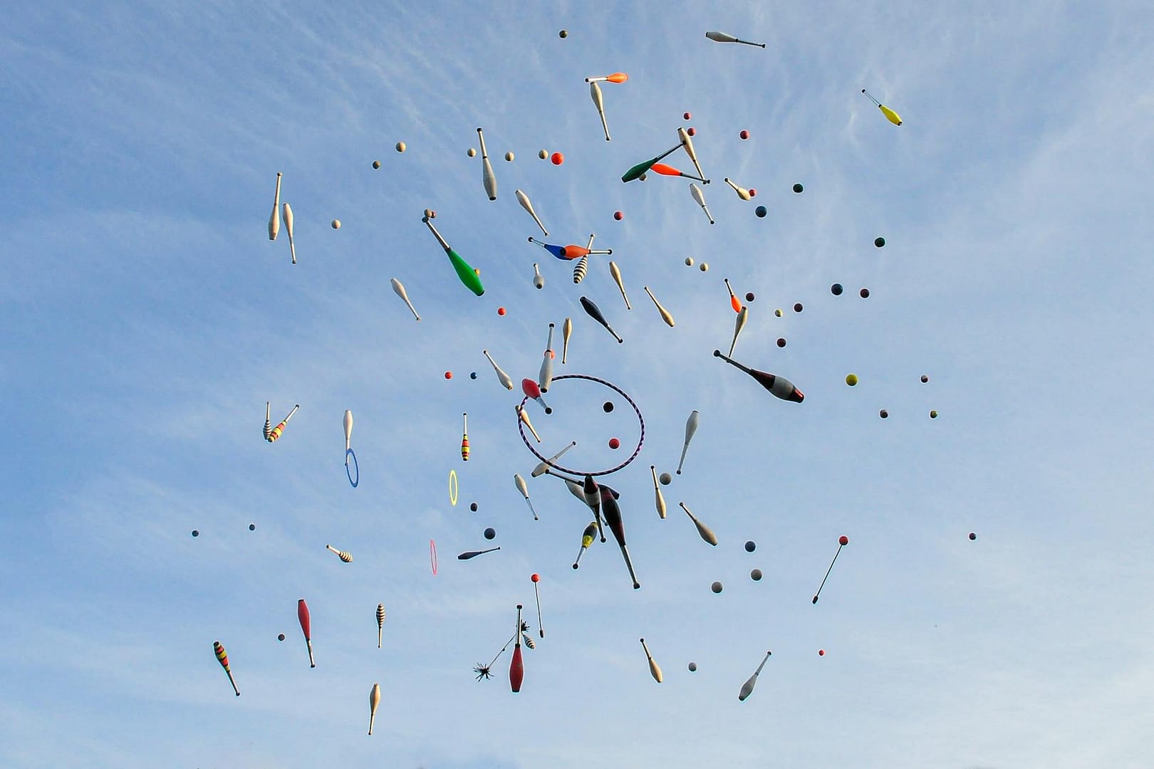 dynamic juggling props against a clear blue sky