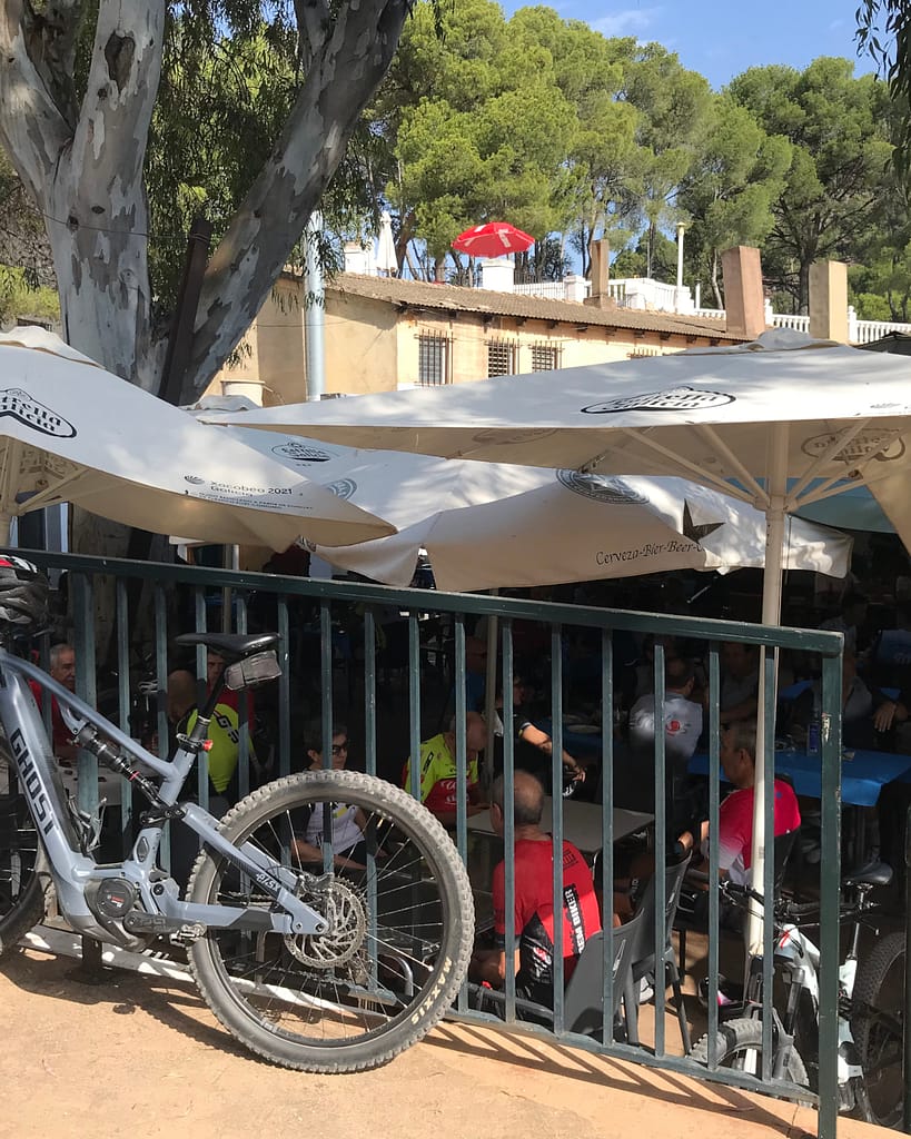 Gallery picture La Garrofera restaurant exterior with shade umbrellas and a bicycle leaning against a guardrail.