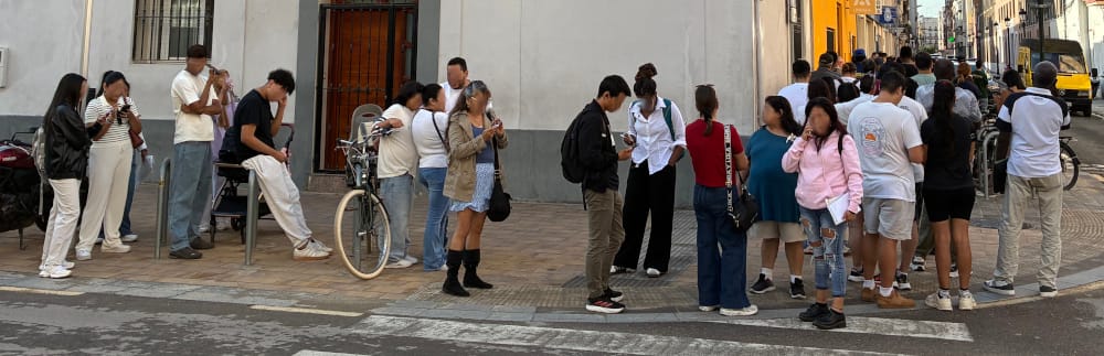 A line of people wait outside the extranjería office to pick up there new TIEs.